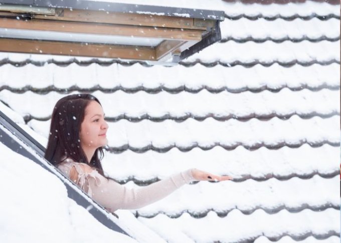 Kobieta cieszy się widokiem z okna dachowego zamontowanego na prawidłowej wysokości